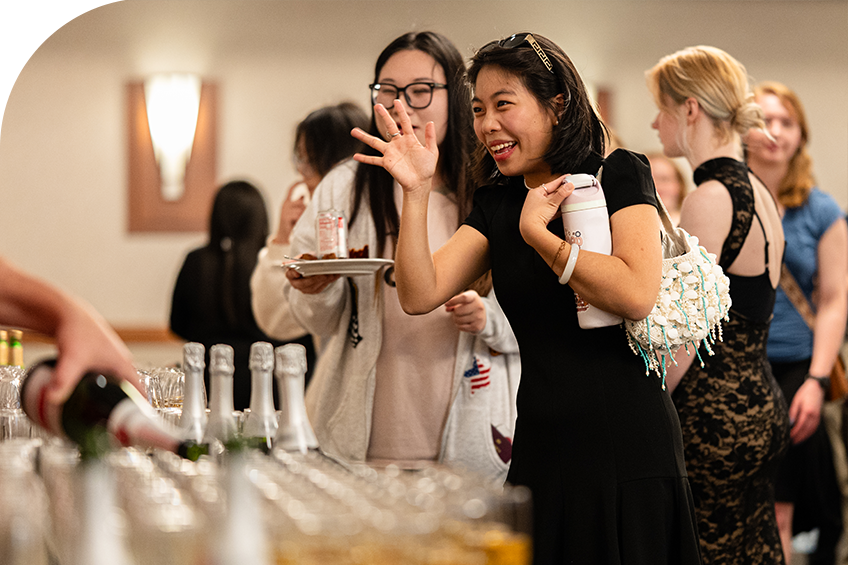 students picking up champagne flutes at senior toast